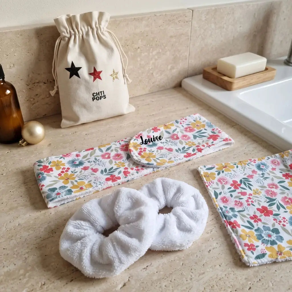 Kit soin visage fleurs multicolores : bandeau prénom Louise, lingette lavable et chouchous éponge sur un plan de vasque