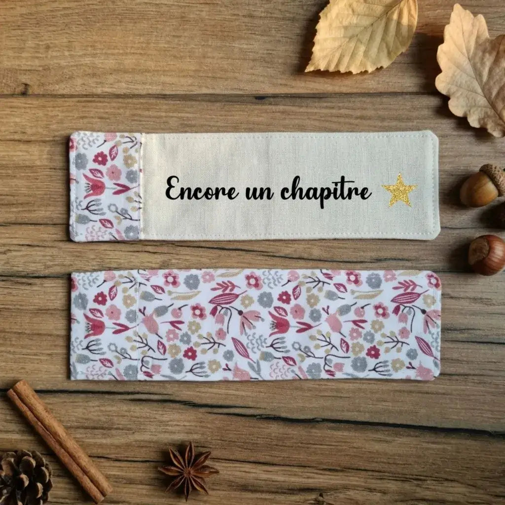 Recto et verso d'un marque-page en tissu floqué Encore un chapitre avec étoile dorée et dos fleuri liberty