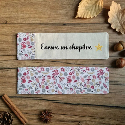 Recto et verso d'un marque-page en tissu floqué Encore un chapitre avec étoile dorée et dos fleuri liberty