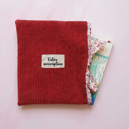 Pochette à livre rouge bordeaux en velours côtelé avec étiquette à personnaliser et livre glissé à l'intérieur