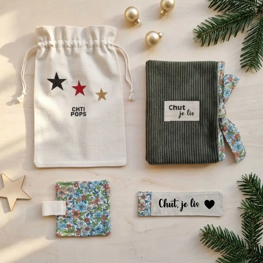 vue de dessus sur fond clair, protège-livre vert kaki « Chut je lis », sous-tasse fleurie bleue avec languette, marque-page avec cœur
