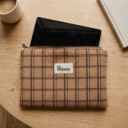 Housse tablette à carreaux noirs sur fond camel au prénom Diane, tablette noire dépassant de la fermeture zippée