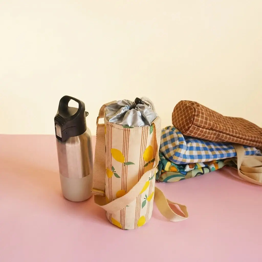Porte-gourde à motif citrons présenté avec d'autres modèles à carreaux et à motifs à l'arrière