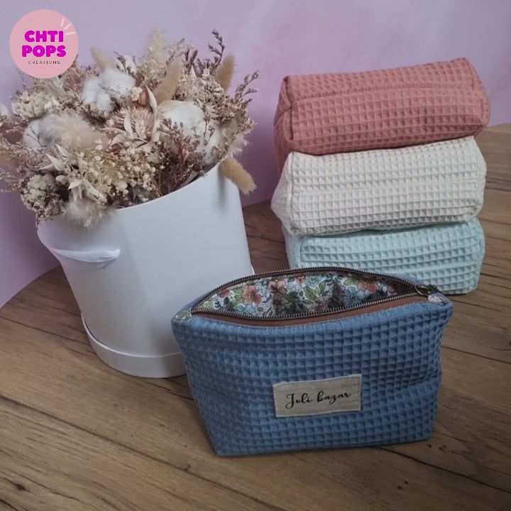 Vidéo présentant les trousses zippées en tissu nid d'abeille par Chtipops Créations. Ces trousses sont personnalisables avec un prénom ou une inscription de son choix floquée sur une étiquette en tissu. L'intérieur est doublé avec un coton imprimé à motif.