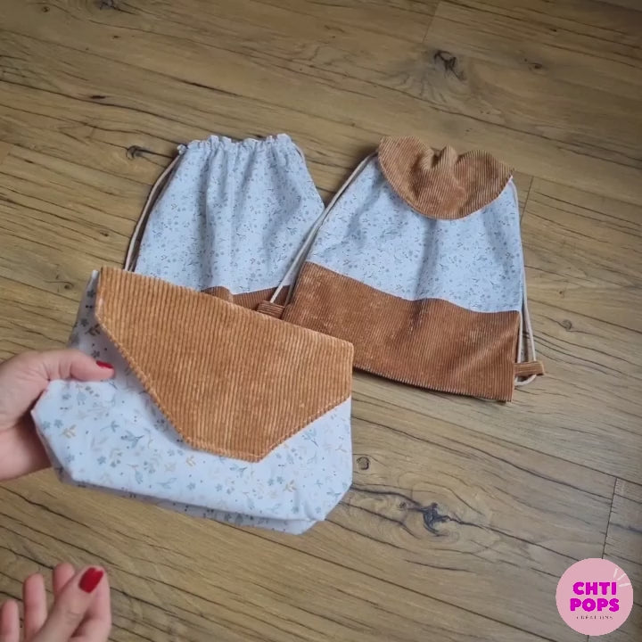 Vidéo présentant un ensemble de 2 sacs à dos au format pochon pour enfant, avec ou sans rabat, base et rabat en velours côtelé marron et tissu imprimé au motif floral azra, avec leur pochette goûter assortie par Chtipops Créations.
