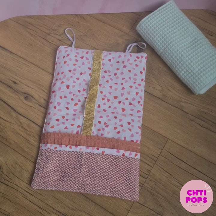 Vidéo de présentation de la pochette de rangement multi-usages en nid d'abeille à rouler et personnalisable par Chtipops Créations. Cette pochette dispose de 4 poches et de 6 compartiments élastiques de différentes tailles pour organiser ses affaires et y ranger câbles, chargeurs, produits de beauté, brosse à dents, etc...