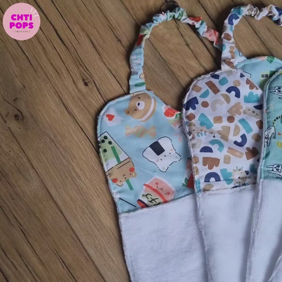 Vidéo de présentation des bavoirs cantines élastiques pour maternelle en éponge de bambou et coton personnalisables au prénom par Chtipops Créations.