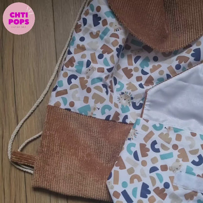 Vidéo présentant le sac à dos format pochon pour enfant au motif ptiwi. Ce sac se décline avec ou sans son rabat en velours côtelé marron. Il est personnalisable au prénom de l'enfant. Une pochette à goûter assortie peut également être associée en option.