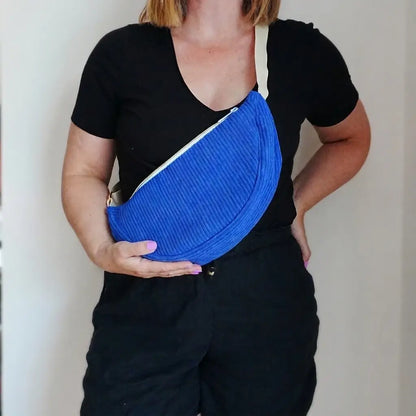 Sac banane bleu roi en velours côtelé porté en bandoulière, sangle écrue et zip diagonal