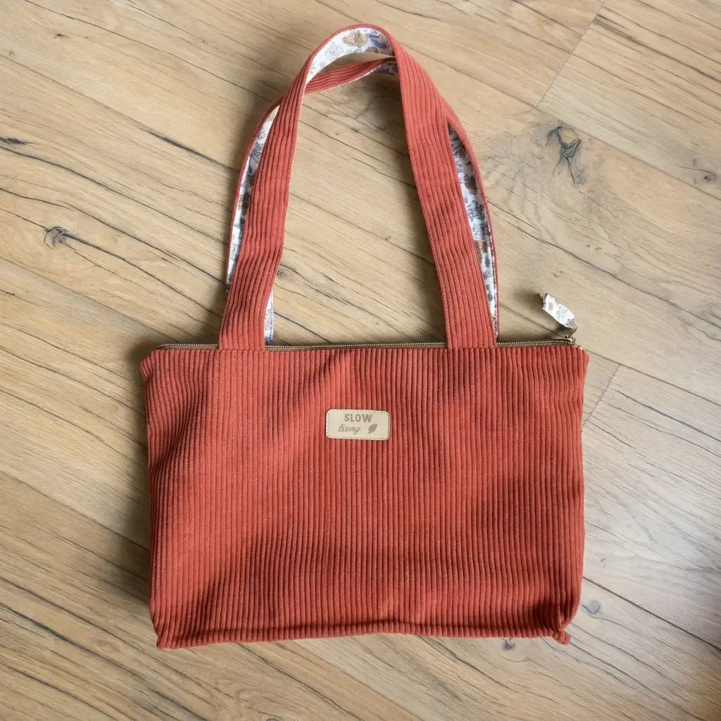Sac cabas terracotta en velours côtelé posé à plat, anses hautes et fermeture zippée dorée