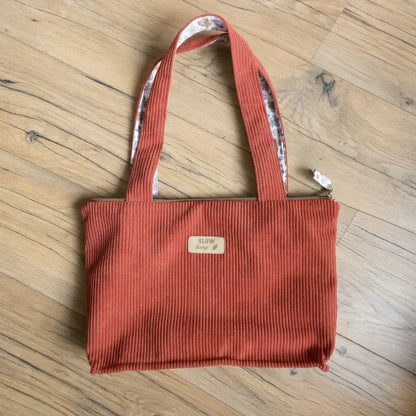 Sac cabas terracotta en velours côtelé posé à plat, anses hautes et fermeture zippée dorée