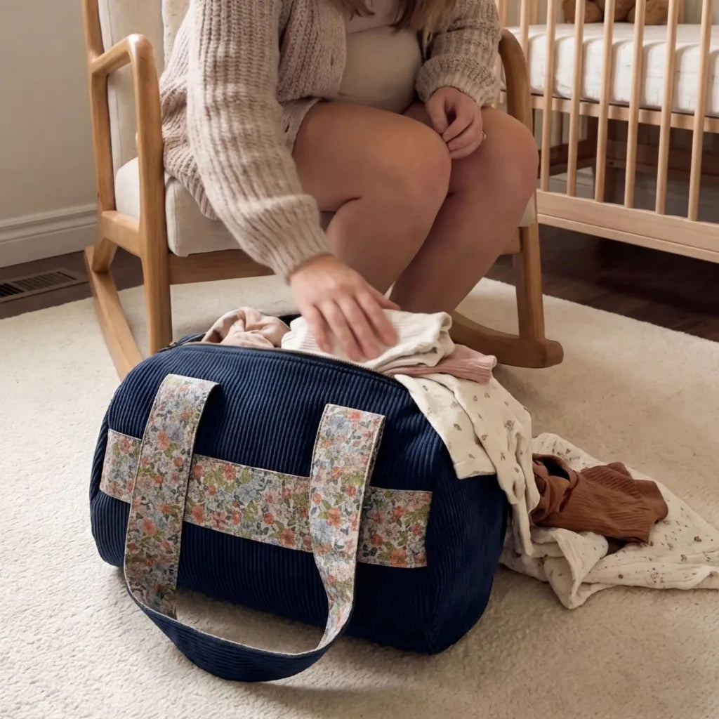 sac polochon velours côtelé bleu foncé dans chambre bébé avec vêtements