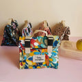 Sac repas à motif abstrait multicolore avec étiquette à personnaliser, autres modèles derrière