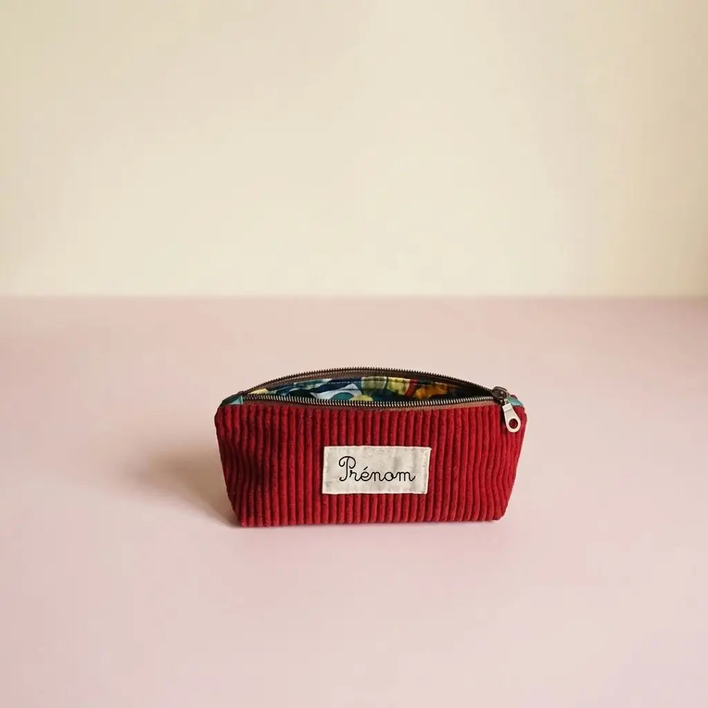 Trousse d'école rouge bordeaux en velours côtelé, zip bronze ouvert sur doublure colorée et étiquette prénom