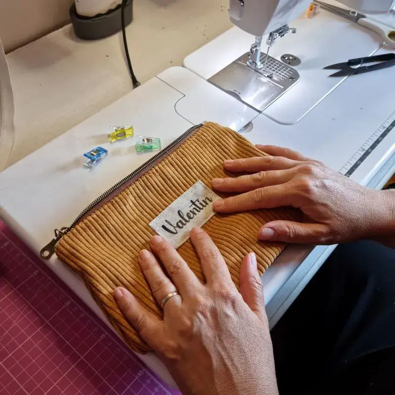 Trousse en velours côtelé moutarde avec étiquette personnalisée au prénom Valentin.