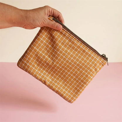 Pochette plate zippée en tissu à carreaux ocre et blanc, zip bronze, tenue en l’air