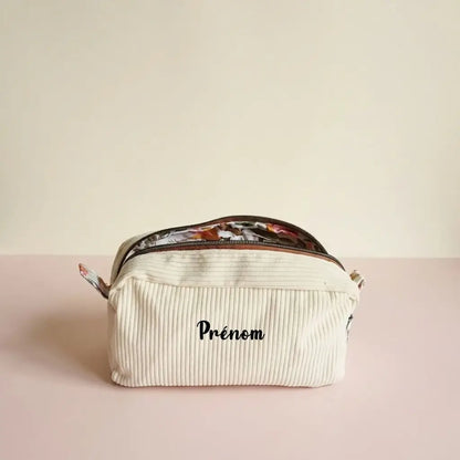 Trousse de toilette jaune pâle en velours côtelé, zip cuivré ouvert sur une doublure fleurie colorée