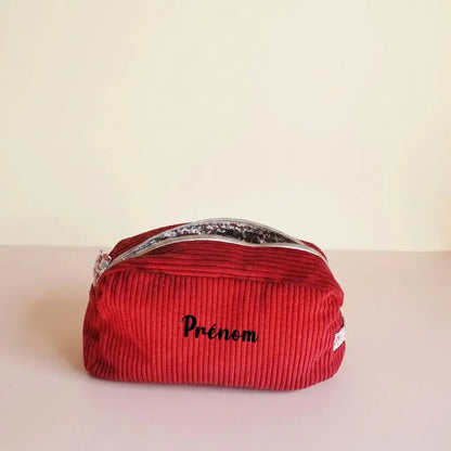 Trousse de toilette rouge bordeaux en velours côtelé, ouverture zippée sur doublure fleurie et prénom au centre
