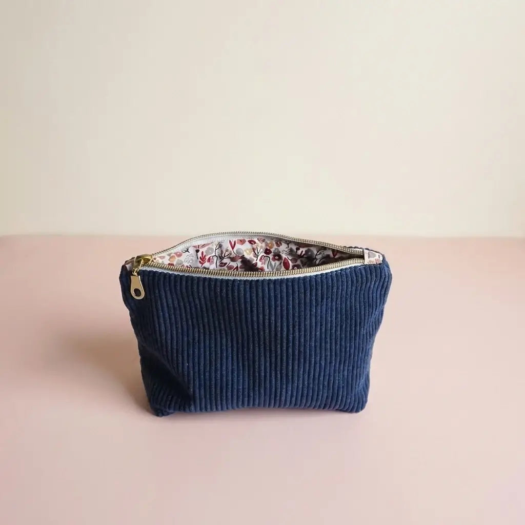 Trousse zippée bleu marine en velours côtelé, doublure à petites fleurs visible par l'ouverture