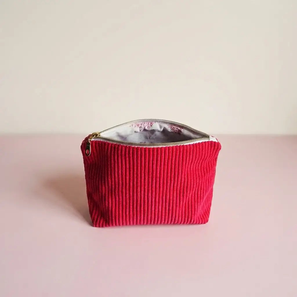 Trousse zippée framboise en velours côtelé, doublure claire à motif rose et zip doré