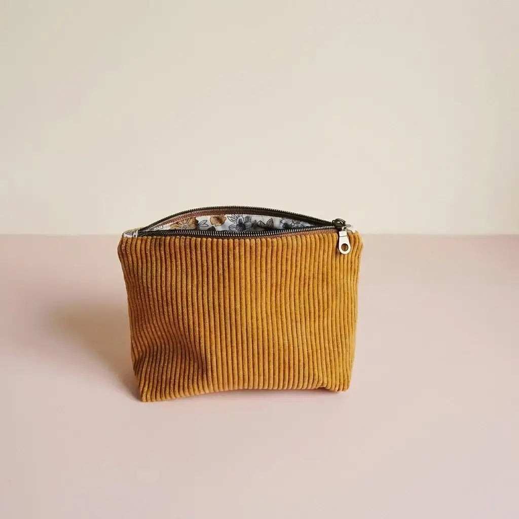 Trousse zippée jaune moutarde en velours côtelé, doublure fleurie visible sous le zip