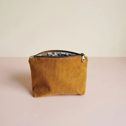 Trousse zippée jaune moutarde en velours côtelé, doublure fleurie visible sous le zip