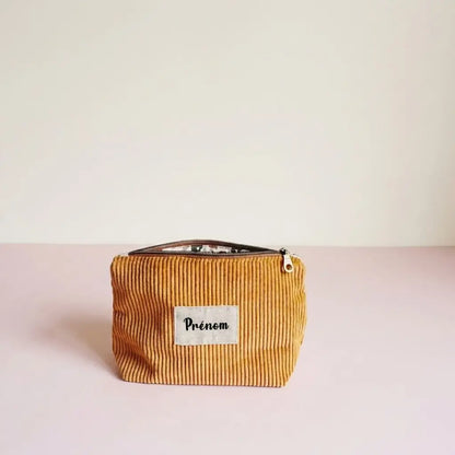 Trousse zippée jaune moutarde en velours côtelé, étiquette prénom et doublure fleurie entrouverte