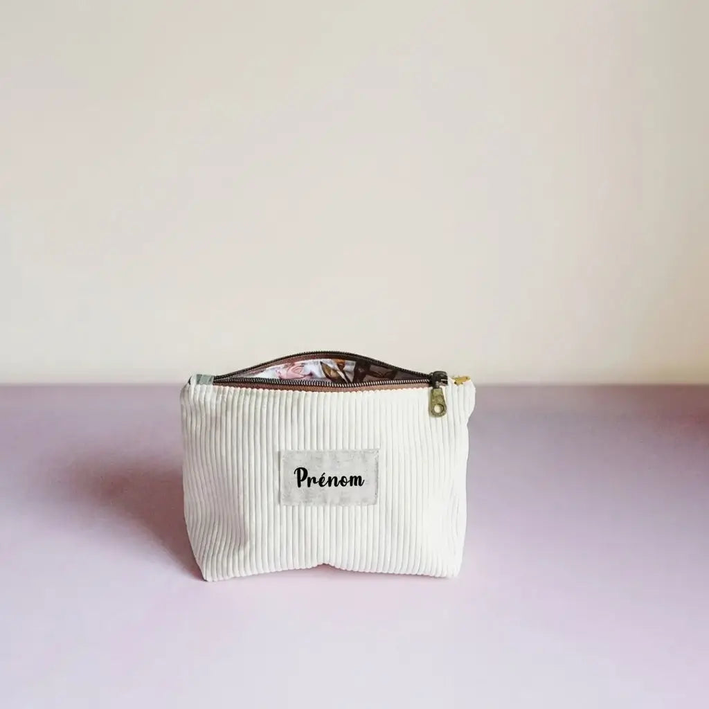 Trousse zippée jaune pâle en velours côtelé, étiquette prénom et doublure fleurie entrouverte