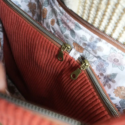 Gros plan sur la double poche zippée intérieure d'un cabas terracotta à doublure fleurie